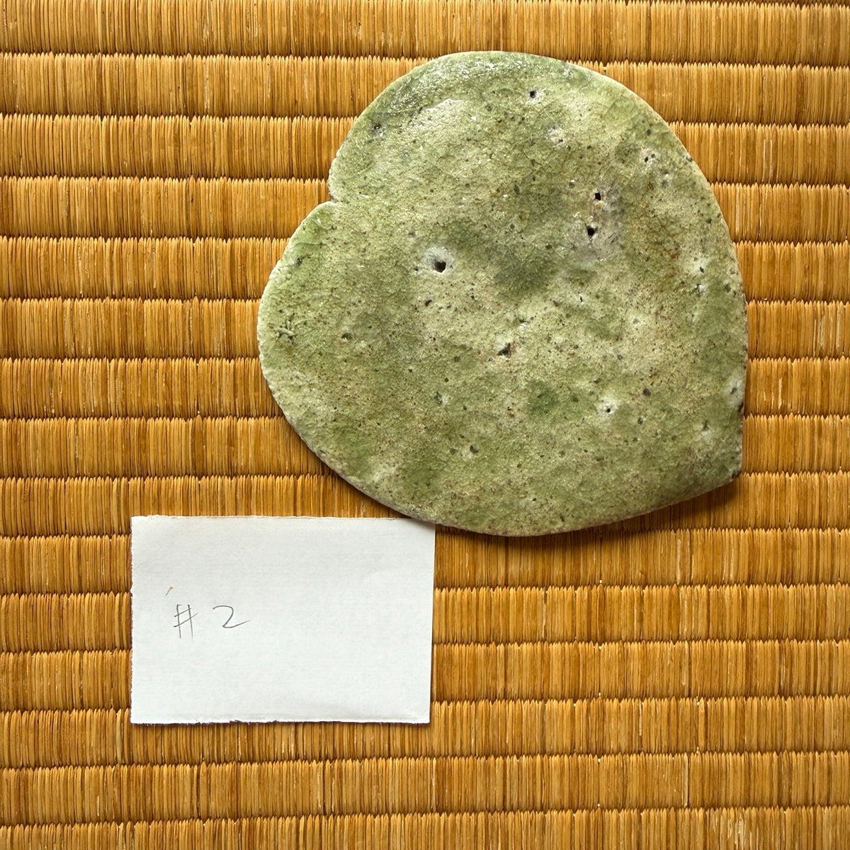 Underside view of plate 2 from the natural ash glaze viburnum leaf dish set by Yui Tsujimura, showcasing a delicate olive-toned ceramic surface with firing pores.