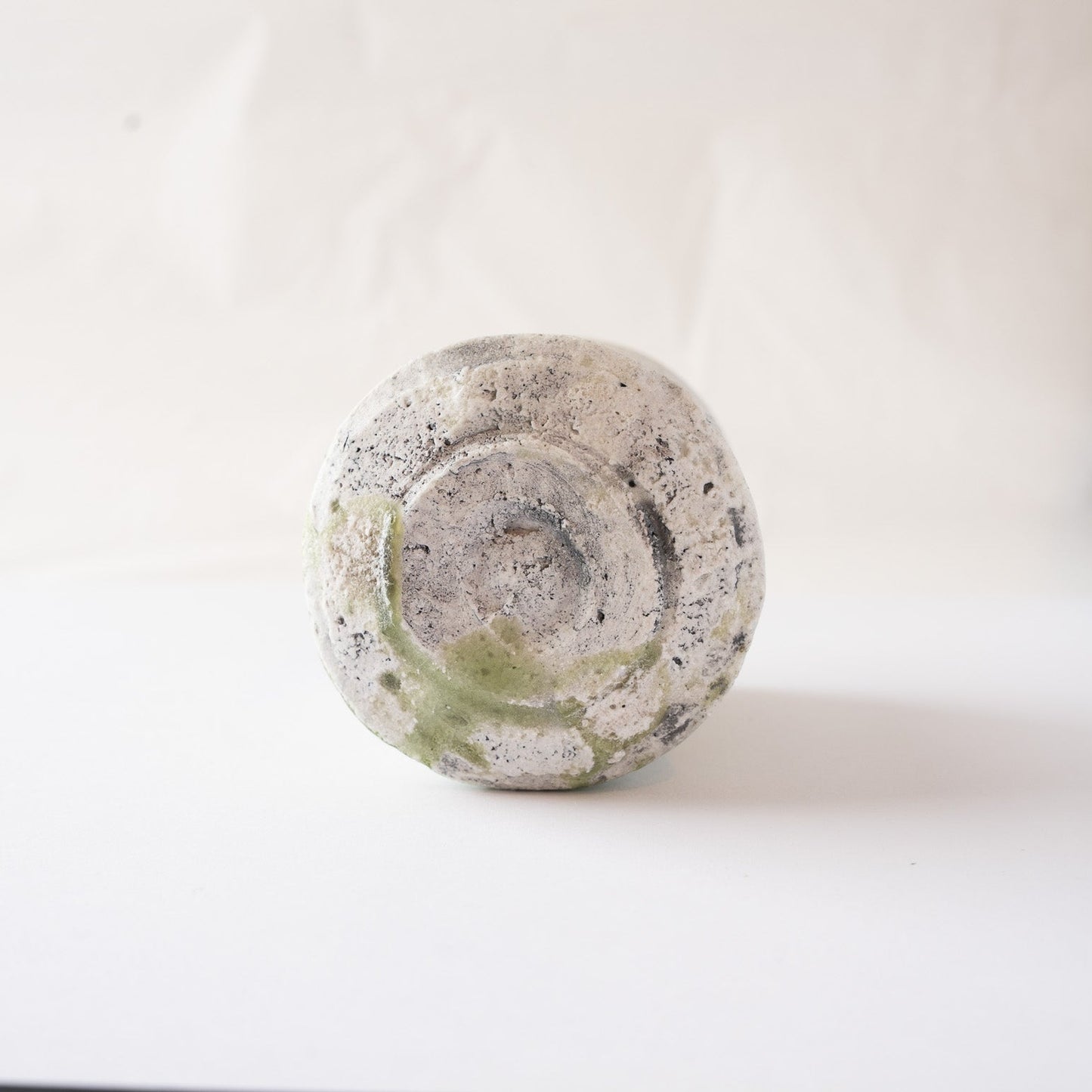 The base of the natural ash glaze YUNOMI cup by Yui Tsujimura, revealing the raw, unglazed clay texture, dynamic tool marks, and traces of firing at the bottom.