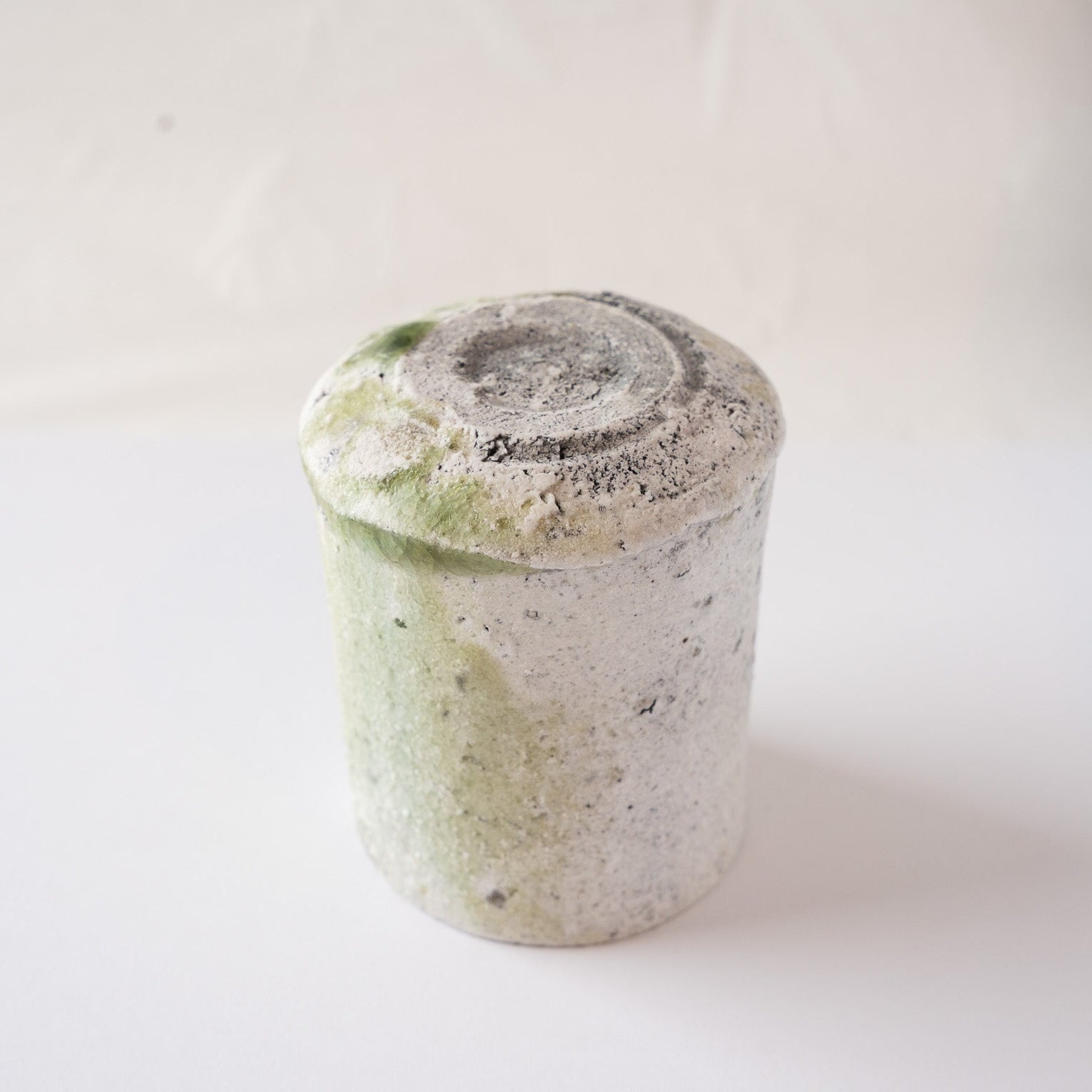 Upside-down view of the natural ash glaze YUNOMI cup by Yui Tsujimura, detailing the dramatic flow of natural glaze and the thick vidro melt at the bottom edge.