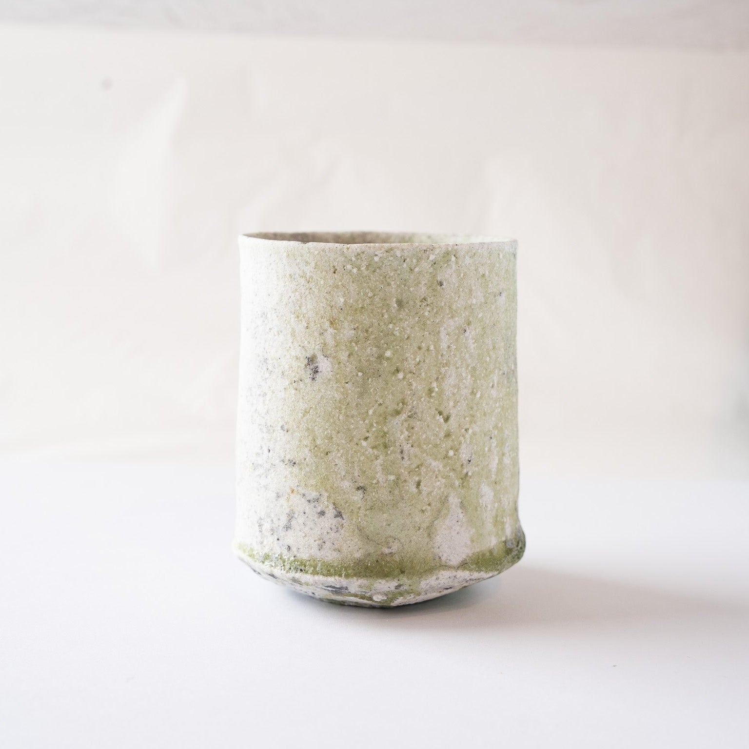 Profile view of the ceramic YUNOMI cup by Yui Tsujimura, emphasizing its straight silhouette, irregular rim, and tactile surface depth.