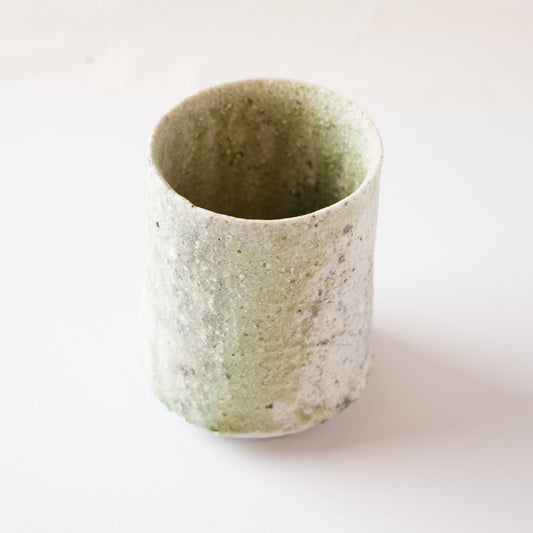 Turned view of the natural glaze YUNOMI cup highlighting the organic transition between the pale green ash glaze and the dry white crystalline surface.