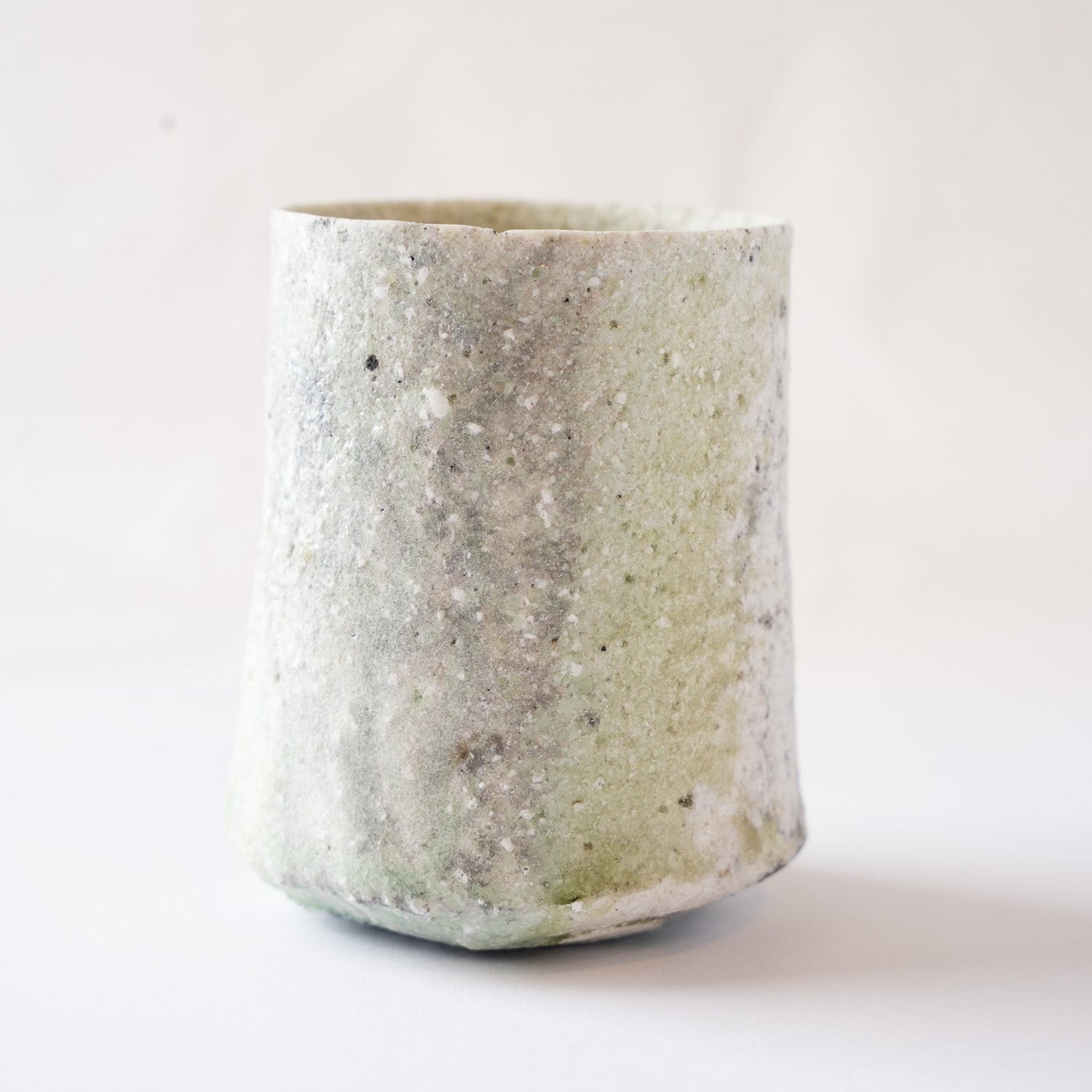 Alternative side profile showing the textured surface where natural green vidro meets the rough, unglazed-feeling white ash glaze.