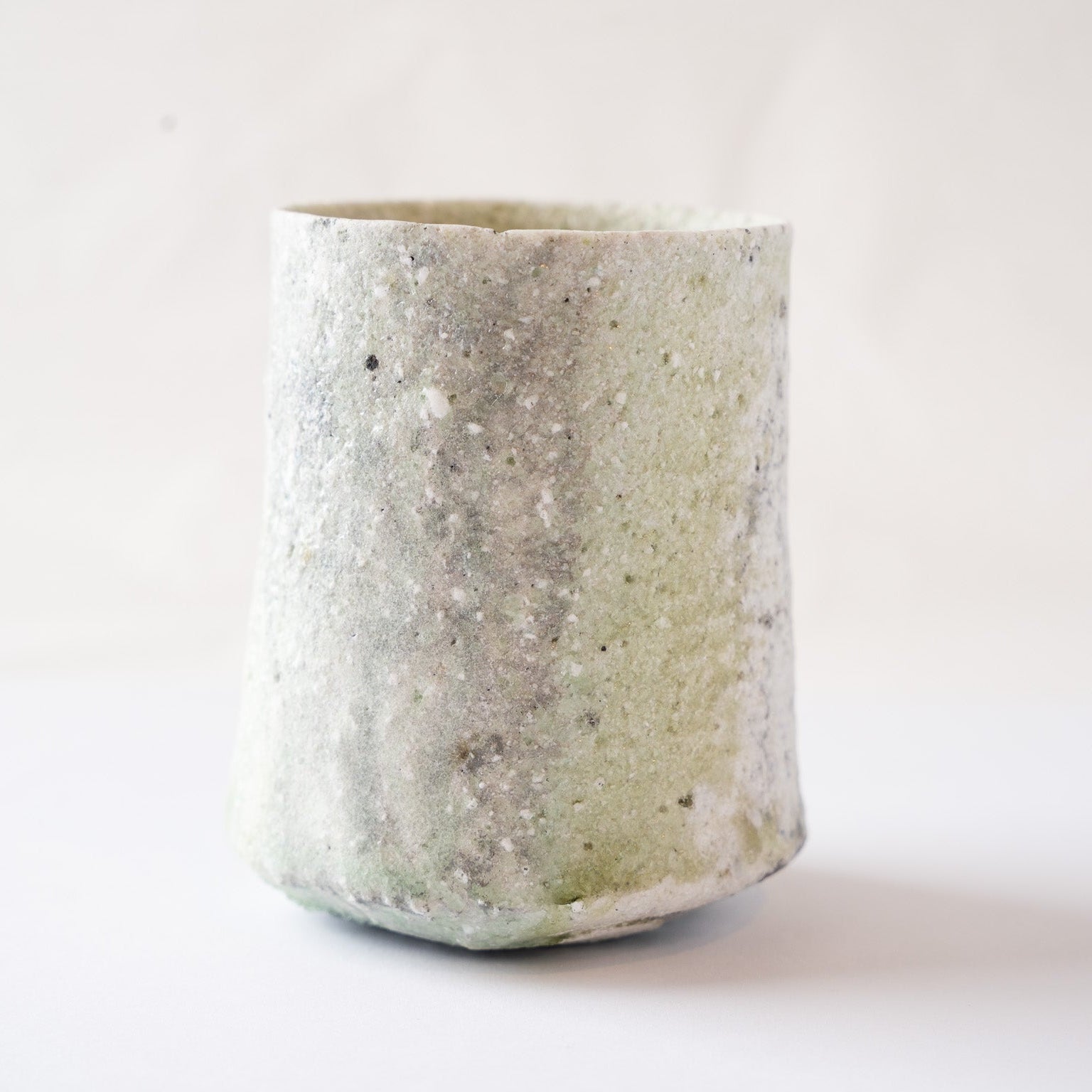 Alternative side profile showing the textured surface where natural green vidro meets the rough, unglazed-feeling white ash glaze.