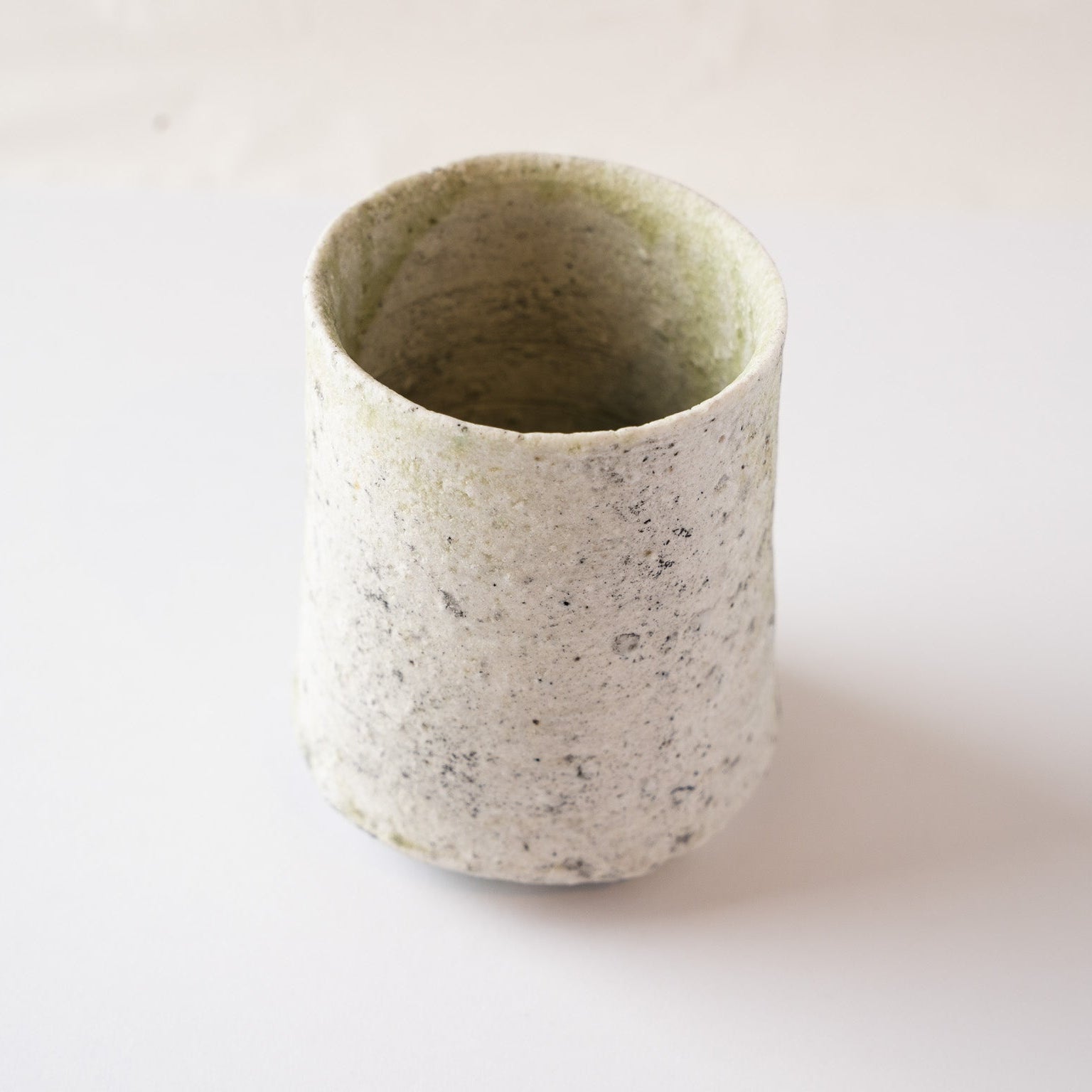 View focusing on the drier, white-speckled side of the YUNOMI cup, showing the raw texture formed by crystallized wood ash.