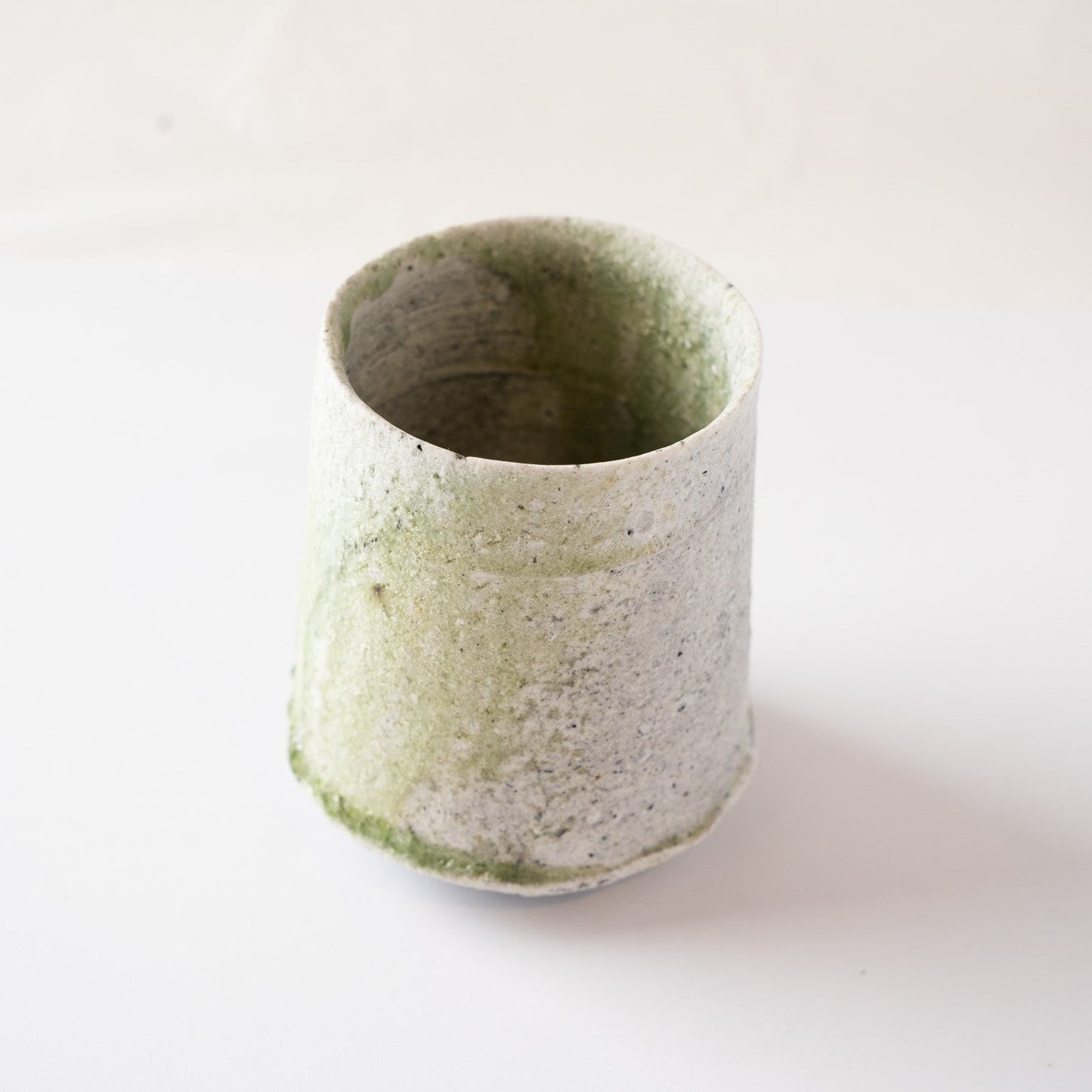 High-angle perspective of the natural glaze YUNOMI cup by Yui Tsujimura, showcasing the rich multi-layered texture and organic rim shape under natural light.